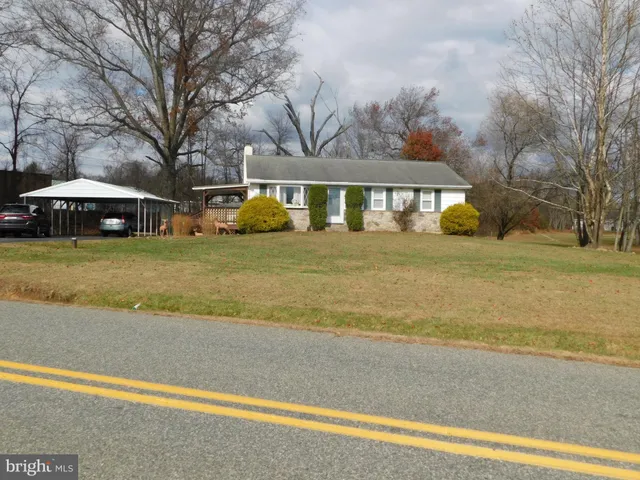 a front view of a house with a garden and trees