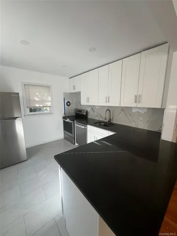a kitchen with stainless steel appliances a refrigerator sink and cabinets