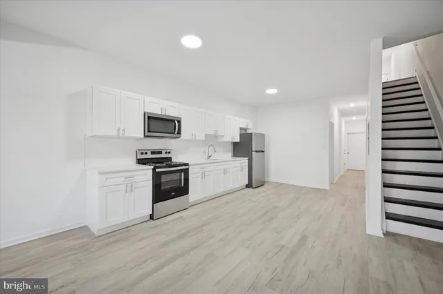 a kitchen with a refrigerator and a stove top oven