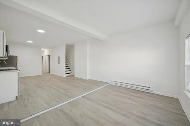 a view of empty room with wooden floor
