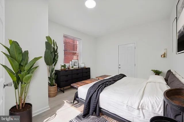 a bedroom with bed and a potted plant