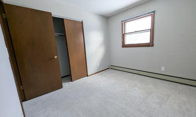 an empty room with windows and closet