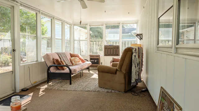 a living room with furniture and a floor to ceiling window