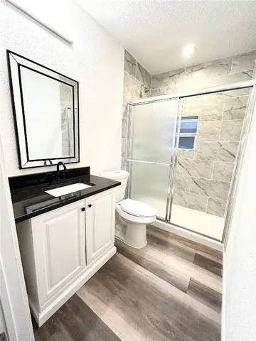 a bathroom with a granite countertop sink mirror vanity and toilet