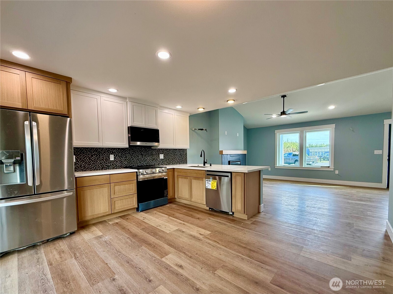 716 Reporter Court Southwest Ocean Shores, WA 98569 - Photo 13 of 36 a large kitchen with a large counter top stainless steel appliances and wooden floor