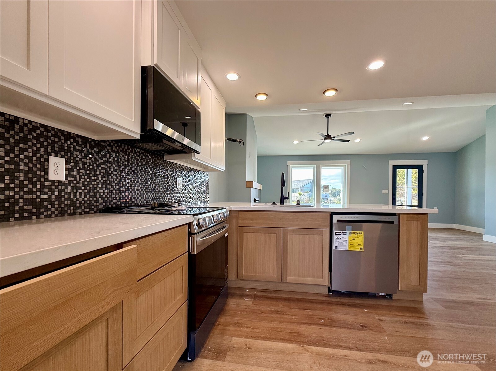716 Reporter Court Southwest Ocean Shores, WA 98569 - Photo 16 of 36 a large kitchen with stainless steel appliances granite countertop a stove a sink and a microwave