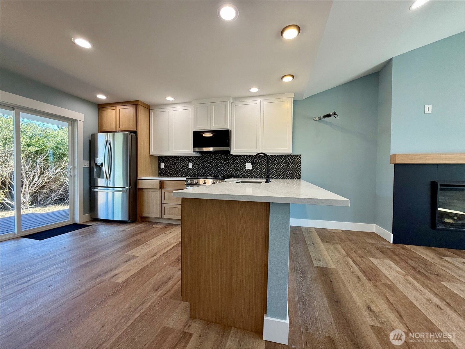 716 Reporter Court Southwest Ocean Shores, WA 98569 - Photo 17 of 36 a kitchen with stainless steel appliances granite countertop a refrigerator a stove a sink dishwasher and a microwave oven with wooden floor