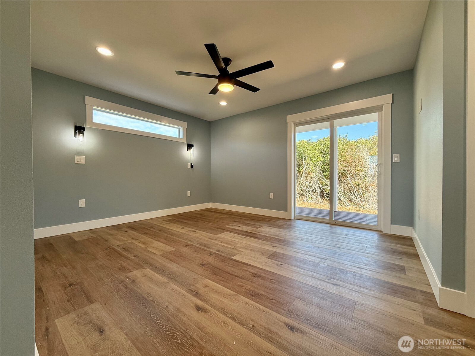 716 Reporter Court Southwest Ocean Shores, WA 98569 - Photo 23 of 36 an empty room with wooden floor fan and windows