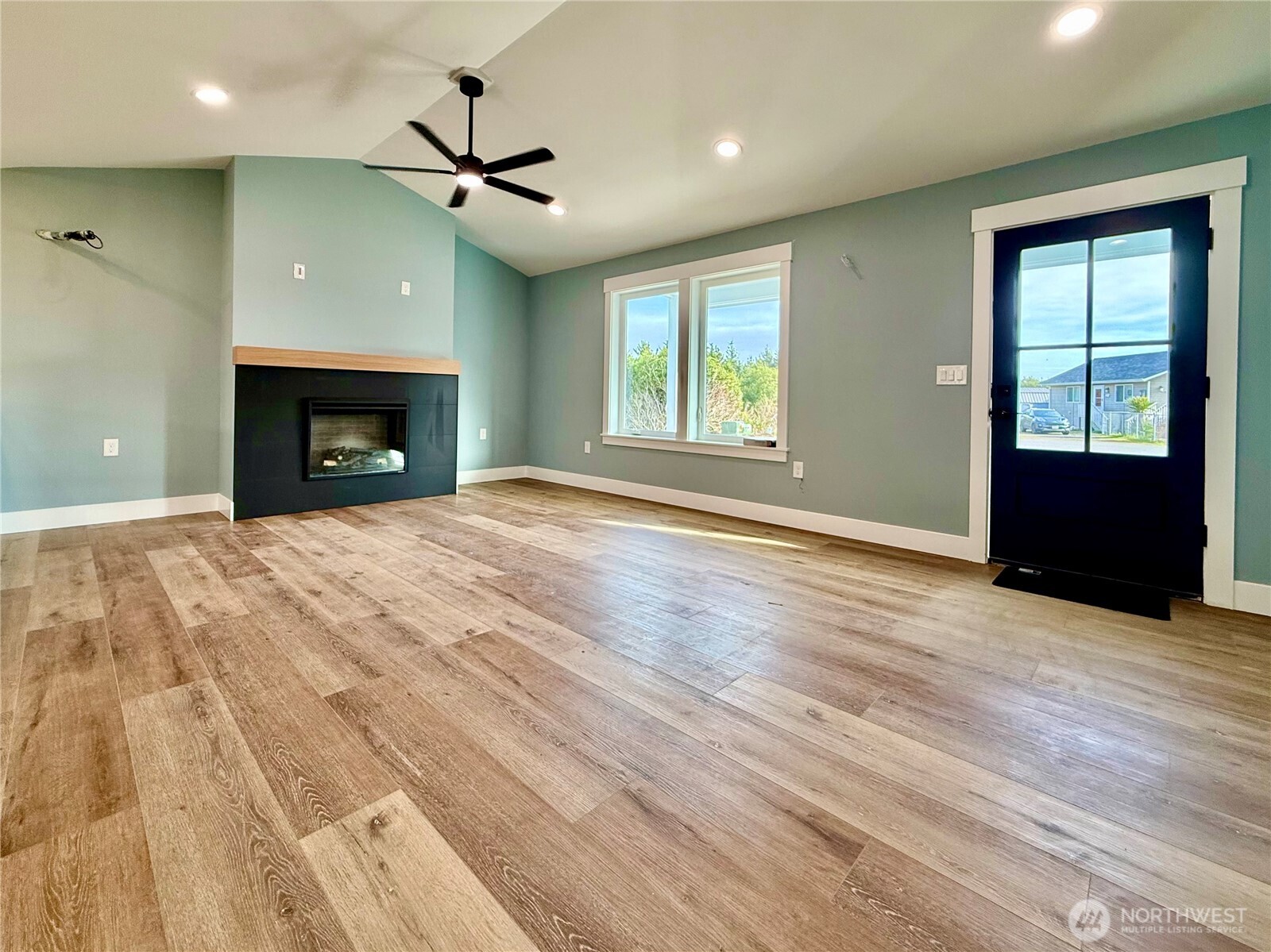 716 Reporter Court Southwest Ocean Shores, WA 98569 - Photo 9 of 36 a view of an empty room with wooden floor fireplace and a window