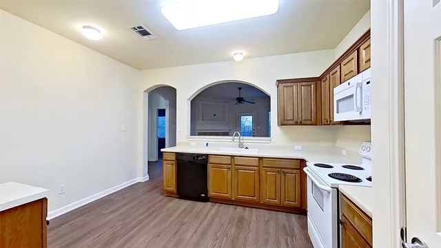 a view of a kitchen with a sink and wooden floor