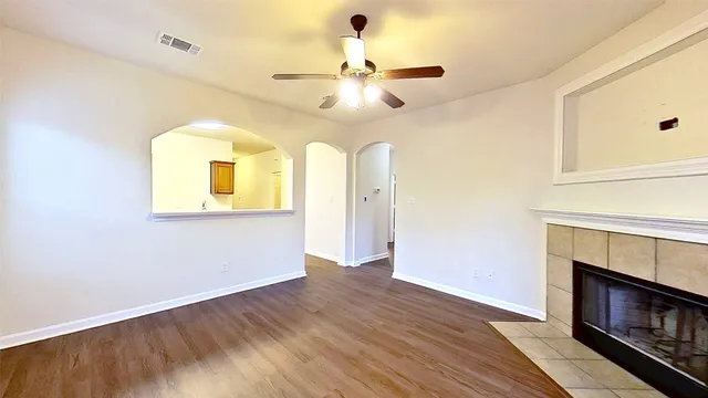 a view of an empty room with a fireplace and a window