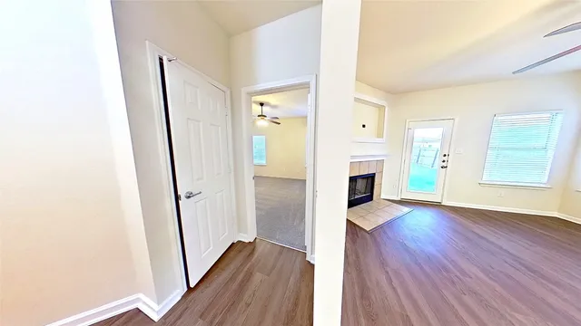 a view of a hallway with wooden floor and a fireplace