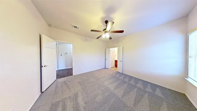 a view of a livingroom with a ceiling fan and window
