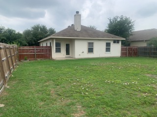 308 Rinehardt Street Hutto, TX 78634 - Photo 28 of 30 Rear view of house featuring a patio area, a fenced backyard, a chimney, and stucco siding