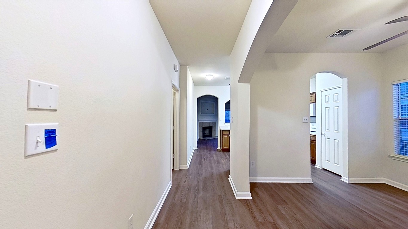 308 Rinehardt Street Hutto, TX 78634 - Photo 4 of 30 Corridor featuring arched walkways and dark wood-style floors