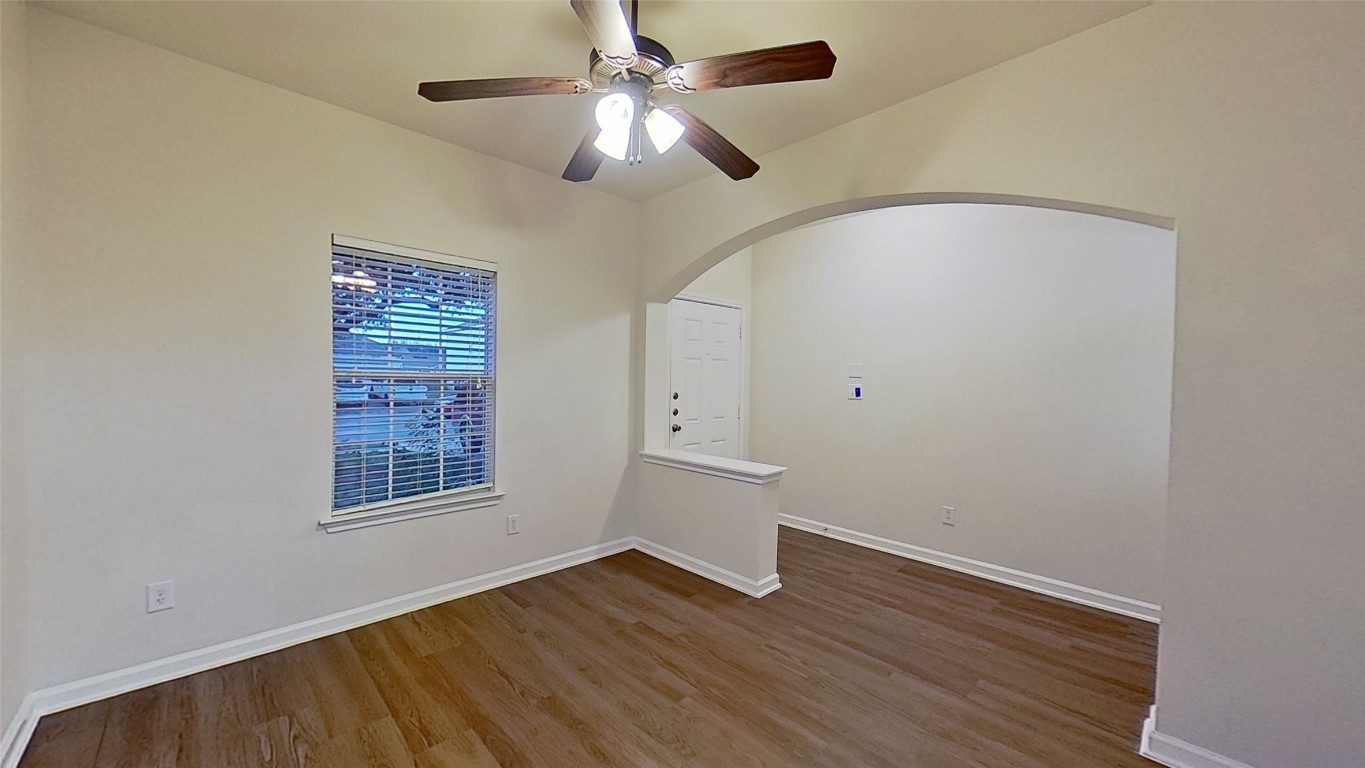 308 Rinehardt Street Hutto, TX 78634 - Photo 5 of 30 Empty room featuring wood finished floors, a ceiling fan, and arched walkways