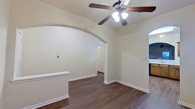 a view of an empty room with window and wooden floor