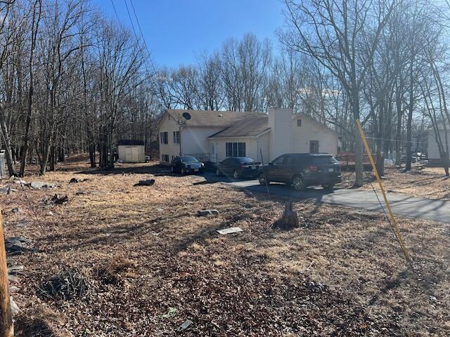 a backyard of a house with large trees and outdoor seating