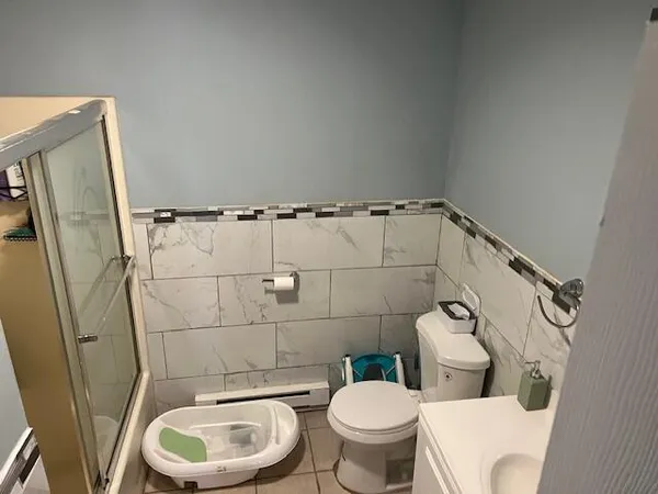 a white toilet sitting next to a bathroom sink and a mirror