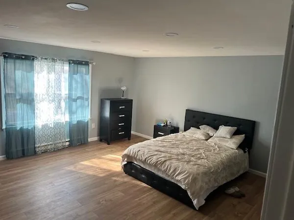 a bedroom with a bed and large window