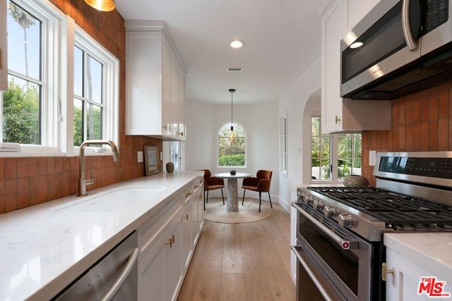 a kitchen with stainless steel appliances granite countertop a stove a sink and a refrigerator