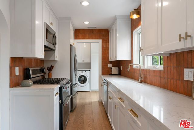 a kitchen with stainless steel appliances a stove a sink and a refrigerator