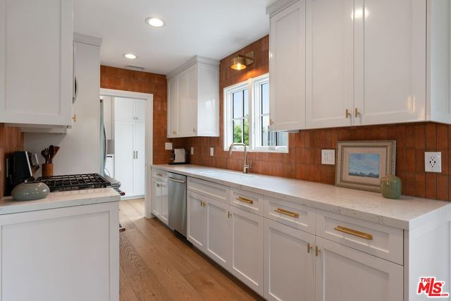 a kitchen with granite countertop white cabinets and white appliances