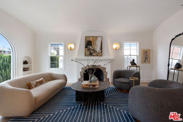 a living room with furniture fireplace and a large window