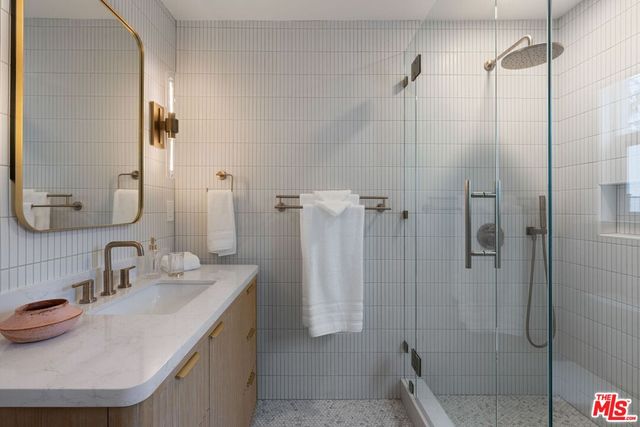 a bathroom with a sink shower and a mirror