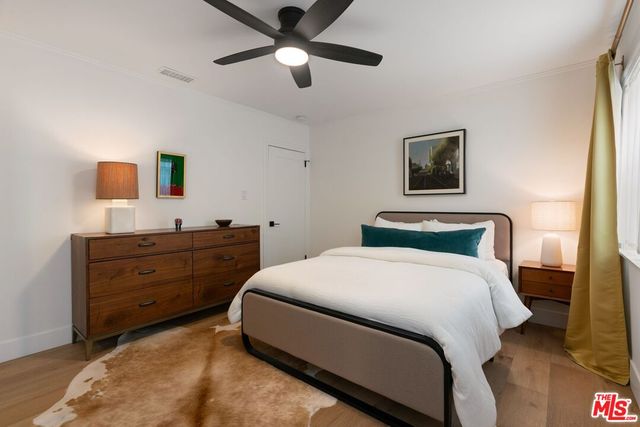 a bedroom with a bed and a painting on the wall