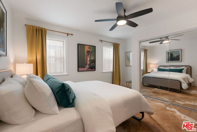 a bedroom with a bed ceiling fan and a window