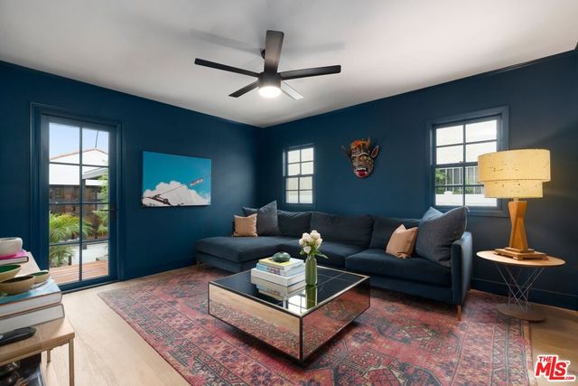 a living room with furniture a window and a flat screen tv