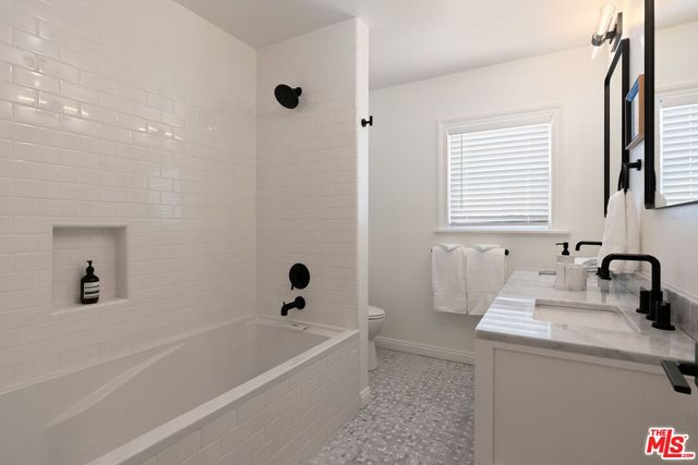 a bathroom with a tub sink and a mirror