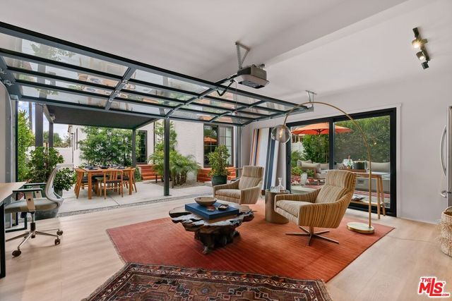 a living room with patio furniture and a potted plant