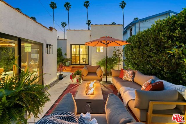 a view of a patio with couches and table and chairs under an umbrella