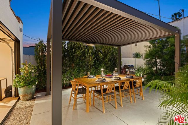 a patio with table and chairs and potted plants