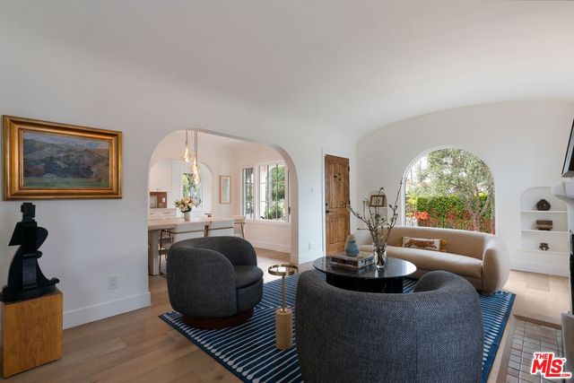 a living room with fireplace furniture and a large window