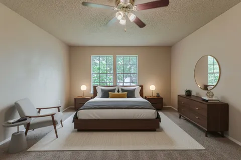 a bedroom with a bed a mirror on dresser and a chandelier