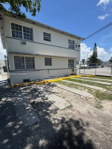 a view of swimming pool with lawn chairs and plants