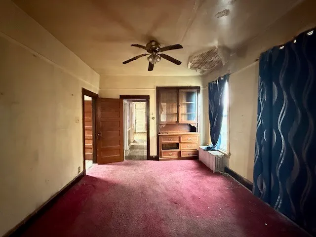 a view of a livingroom with a ceiling fan and window