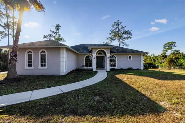a front view of house with yard and trees