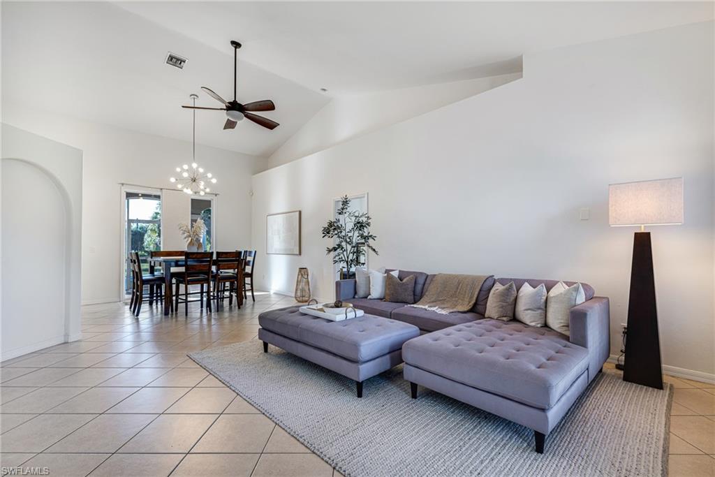 461 Everglades Boulevard North Naples, FL 34120 - Photo 4 of 16 Living area featuring light tile patterned floors, high vaulted ceiling, ceiling fan, and a chandelier