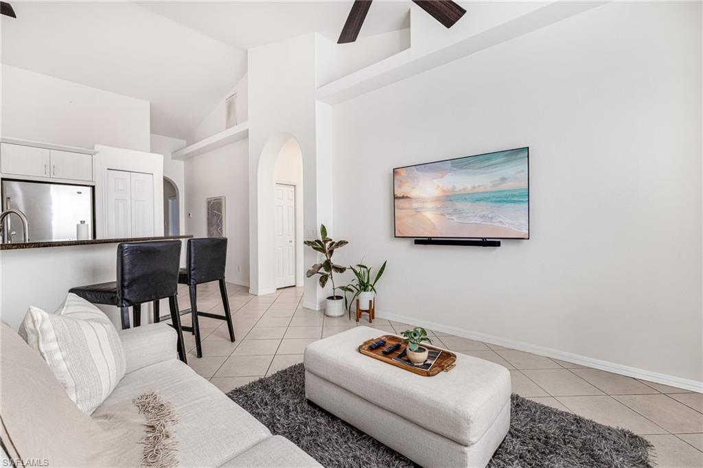 461 Everglades Boulevard North Naples, FL 34120 - Photo 7 of 16 Living room with arched walkways, high vaulted ceiling, light tile patterned floors, and a ceiling fan