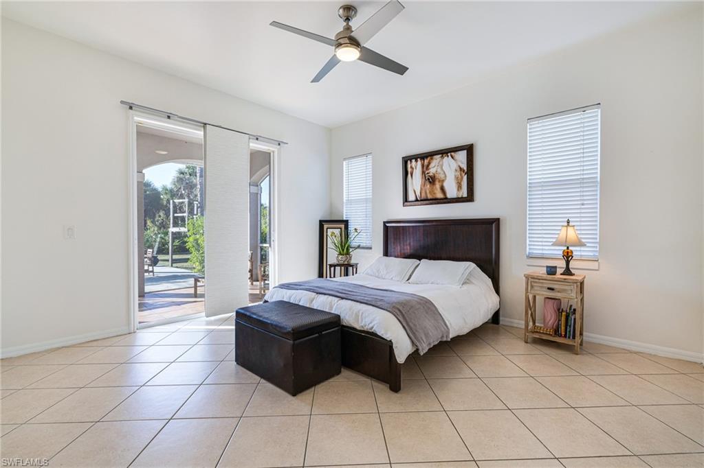 461 Everglades Boulevard North Naples, FL 34120 - Photo 8 of 16 Bedroom featuring access to outside, multiple windows, light tile patterned floors, and a ceiling fan