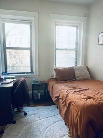 a bedroom with two beds and a window