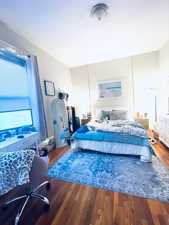 a bedroom with a bed and wooden floor