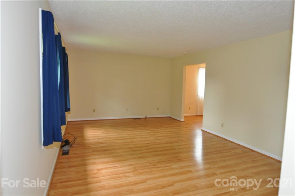 801 Charity Road, Unit 6 Chester, SC 29706 - Photo 3 of 26 a view of an empty room with wooden floor and a window
