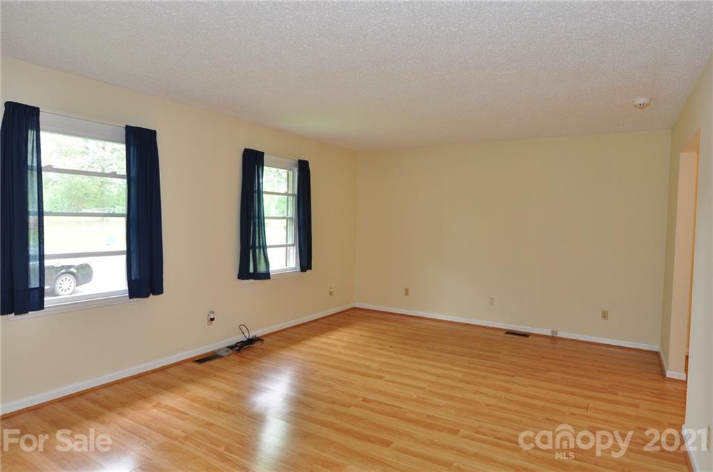 801 Charity Road, Unit 6 Chester, SC 29706 - Photo 4 of 26 a view of an empty room with wooden floor and a window