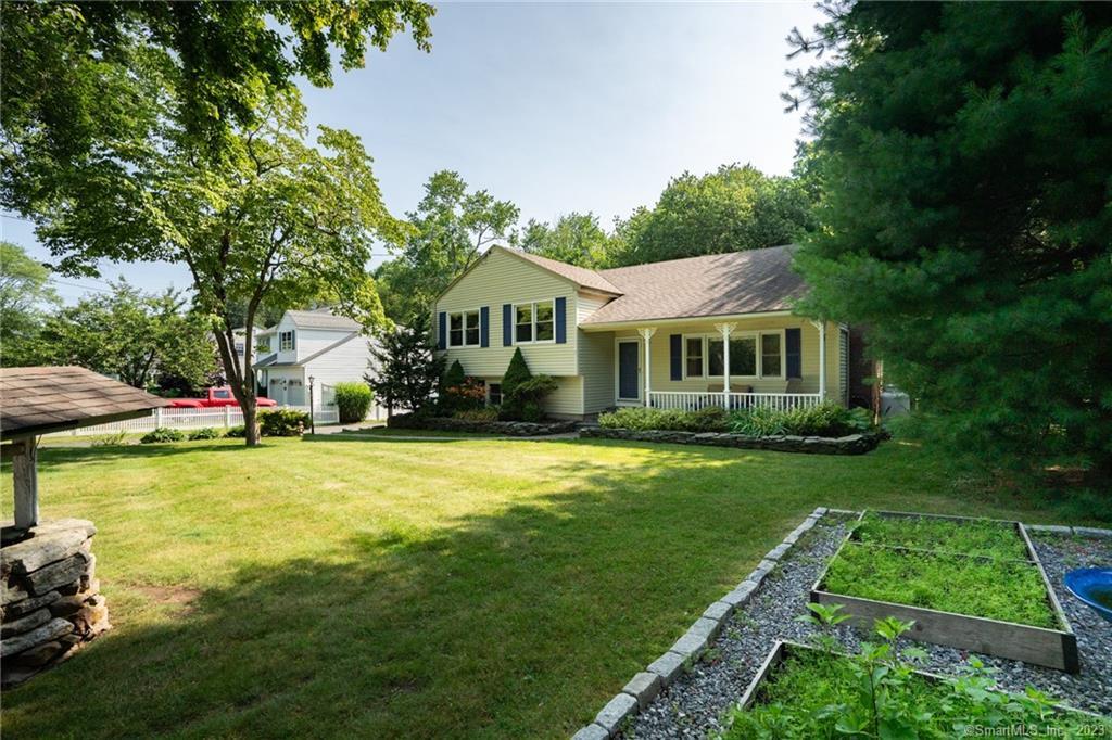 69 Twin Coves Road Madison, CT 06443 - Photo 1 of 1 a front view of a house with a yard table and chairs