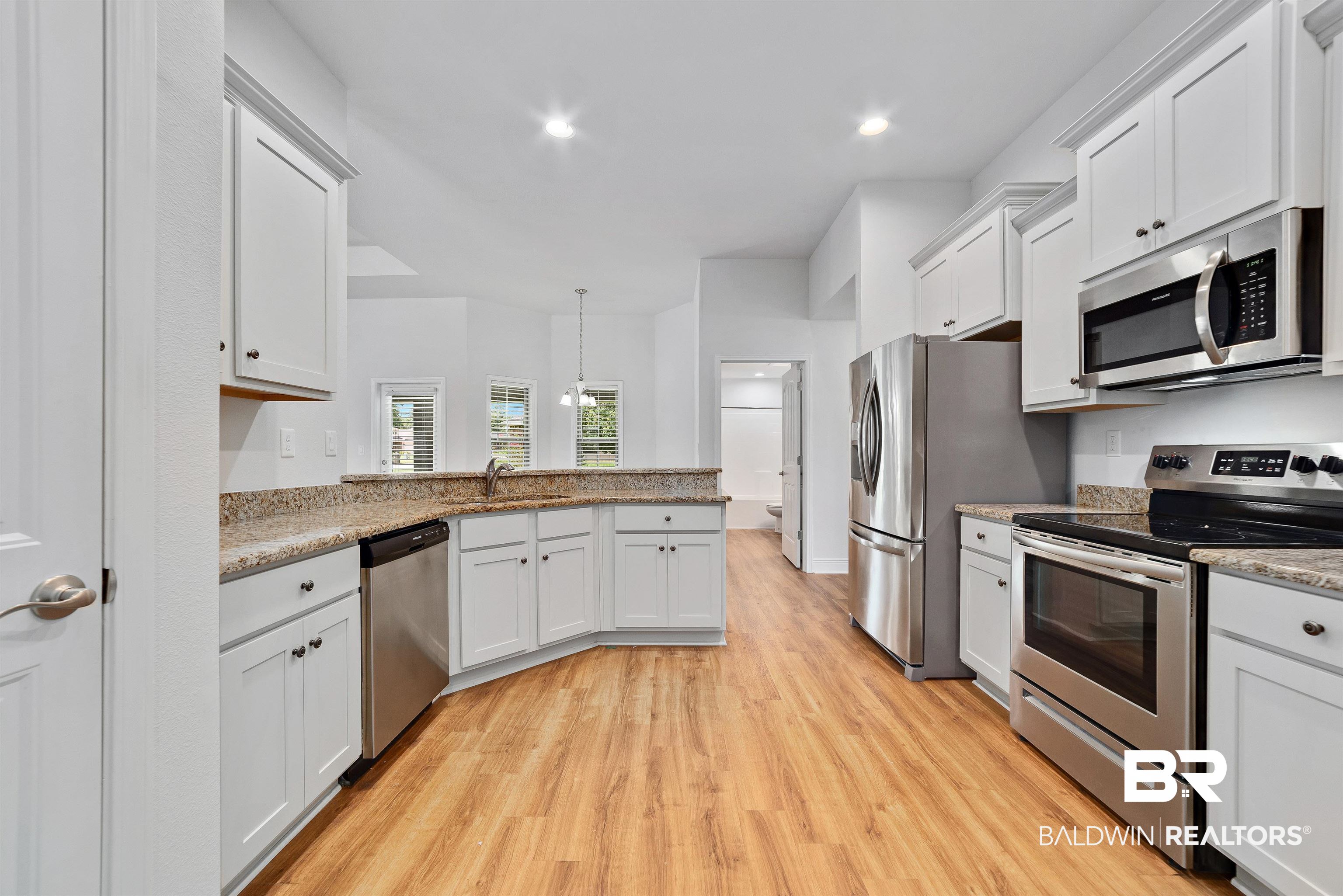 13155 Wishbone Court Foley, AL 36535 - Photo 17 of 39 Kitchen featuring stainless steel appliances, sink, kitchen peninsula, light wood-type flooring, and white cabinetry